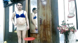 性感的娘娘腔变装者femboy Sweet棒棒糖在围裙上，胸罩和裙子。