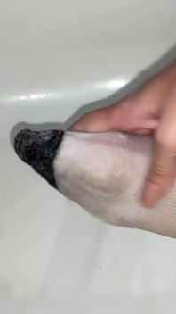 Massagem com óleo do pé em meias do tornozelo