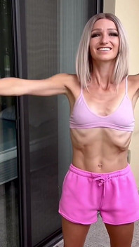 Flaca rubia en forma estira y entrenamiento en el balcón