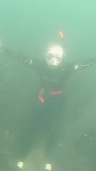 Ragazza libera in acqua aperta con pinne ultra lunghe, mutando e attrezzatura per snorkeling