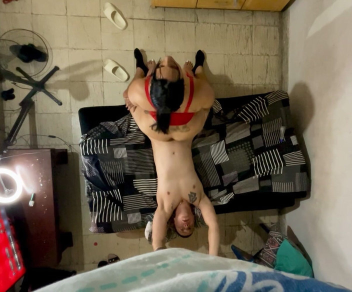 Monozion: Große Frau, die ihren Mann in rotem String sitzt