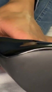 La ragazza ebano fa un gioco di scarpe con i suoi tacchi neri e mostra la sua nuova pedicure sui suoi piedi