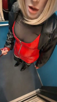 Promenade dans une maison de parking, une blonde dans des bottes overknee, robe en pvc rouge et long manteau de cuir