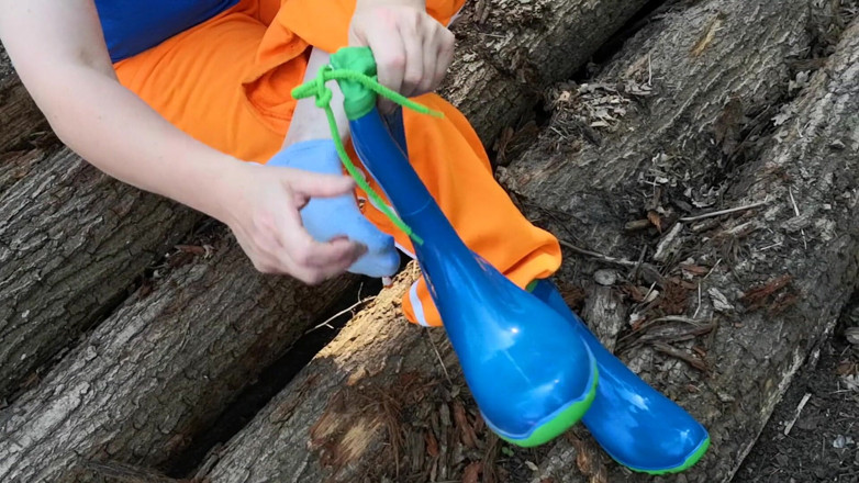 Bouncy Tits Action: Sitting in rubberboots on woodpile