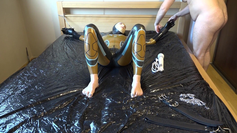 Latex Danielle: Latex Danielle is attached to the bed and masturbated with...