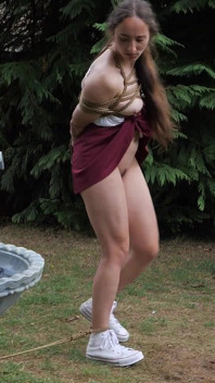 Mila, esclave à demi déshabillée qui branle le ventre, bave à travers la pince de la langue, se fait promener dans la fontaine extérieure avec une scie à la corde