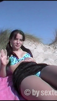 A hairy teen shoots her boyfriend with a camera on the beach