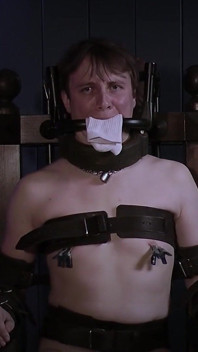Ricky bir bondage sandalyesinde, çelik gag ve çorap pedasyonunda.