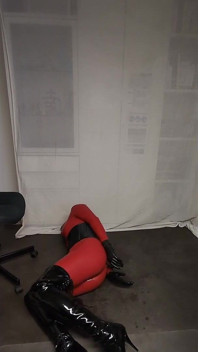 Roter latex-catsuit, blondine in Overknees, anziehen und bereit für session, geknebelt, handschellen