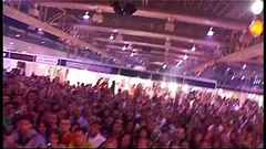 Two girls pleasing a guy in front of an audience