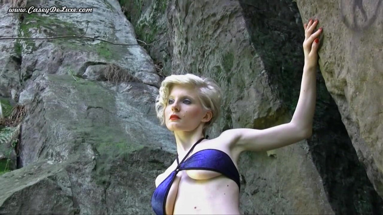 Casey Deluxe: Busty blonde posing naked at the rocks