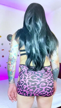 Chica trans en su vestido corto montando un enorme consolador y corriéndose