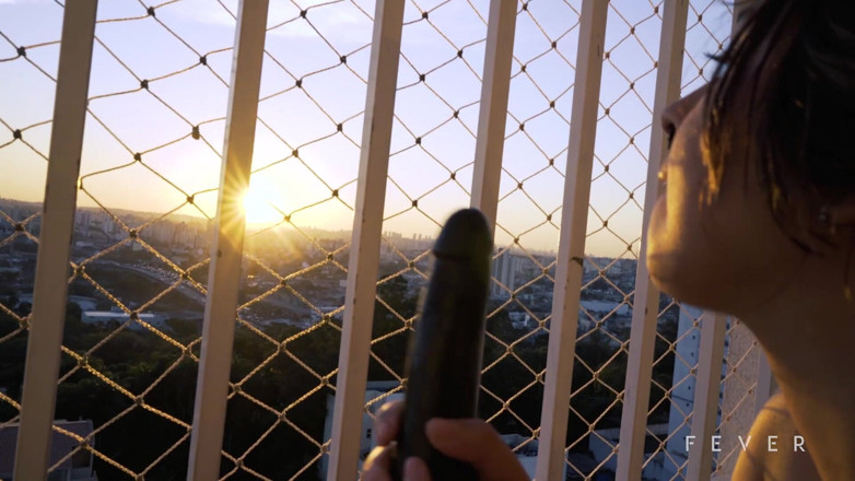 Fever Films: Une brune sur le balcon joue avec sa chatte pour...
