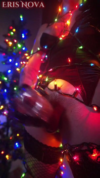 Eris Nova wichst in weihnachtsbeleuchtung eingewickelt
