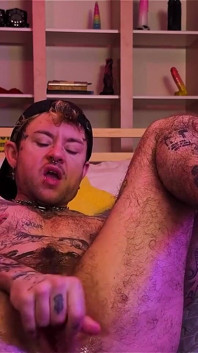 Ftm Xxxskips tatuat se acoperă în ulei, își freacă picioarele goale, se joacă cu pizda lui trans până când ejaculează