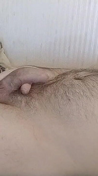 Molliger schwuler masturbiert auf dem bett und kommt auf den behaarten bauch