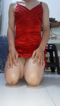 Kırmızı saten seksi mini elbise giyen travesti ve fışkırtıyor
