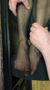 Pernas sensuais na meia-calça com pés pequenos