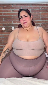 ベッドの上で逞しい女性の大きなお腹をマッサージ:かさばるお腹と体の愛撫。