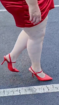 Hermosa mujer caminando al aire libre en el estacionamiento mostrando para extraños