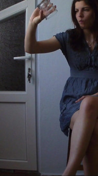 สาวเงี่ยนบนเก้าอี้ดื่มน้ำผลไม้แล้วเล่นกับตัวเอง