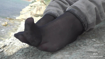 Mistress Legs: Picioare cu blugi în șosete negre din nailon pe malul mării