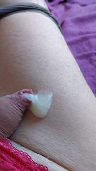 Un cocu en culotte et des talons jouit sur une jambe lisse
