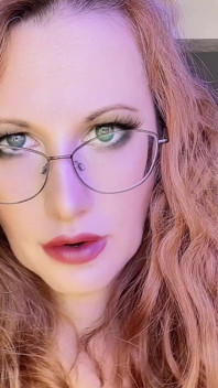 Kızıl saçlı orta yaşlı seksi kadın edepsizce konuşuyor ve seksi dudaklarını ve azgın yüzünü azdırıyor