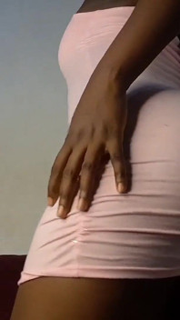 Une belle-fille noire en robe moulante rose taquine