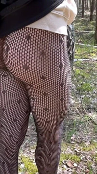 Walking in a park in fishnet tights.