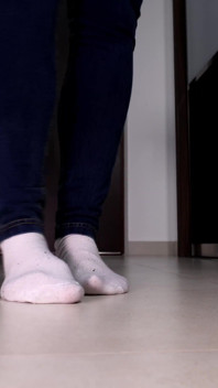 Calcetines blancos gastados en primer plano provocando con sus grandes pies