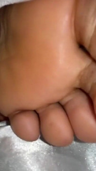 乌木女孩在床上的封面下炫耀脚