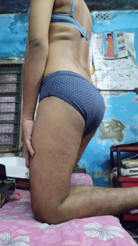 Cậu bé tuổi teen Ấn Độ mặc áo ngực màu xanh và quần lót chấm