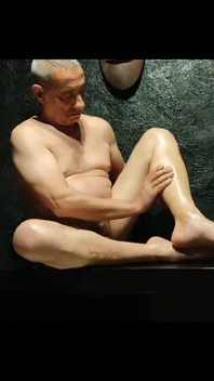 Un Homme Tuga Passe De L’huile Sur Ses Jambes