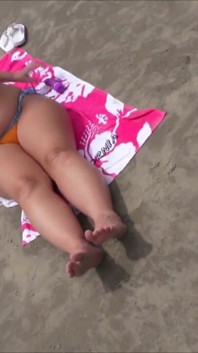 Une femme se masturbe sur la plage