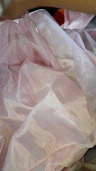 Sentindo calmamente a maciez e suavidade do vestido de cetim escorregadio e brilhante da enteada