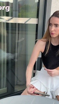 Ragazza del college carina e calda senza faccia va senza mutandine con una minigonna per mostrare la sua figa carnosa stretta e il suo culo nudo sul balcone