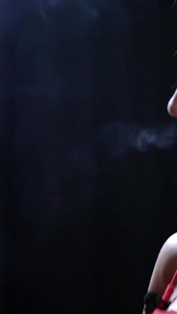 Sexy senhora de vermelho está fumando dois vermelhos 100mm