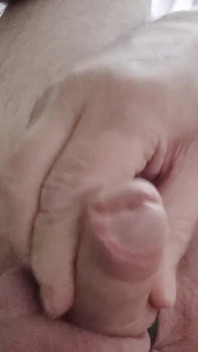 Mon ami s’assoit sur une chaise, joue avec sa petite bite et regarde des vidéos