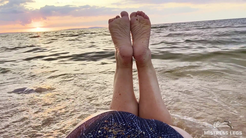 Mistress Legs: Güzel buruşuk tabanlar ve ayak parmakları deniz plajında gün batımının...