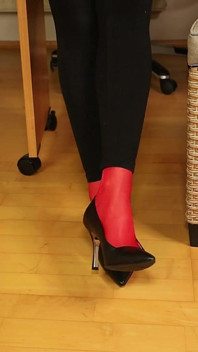 Meias vermelhas, salto alto e leggings pretas provocam