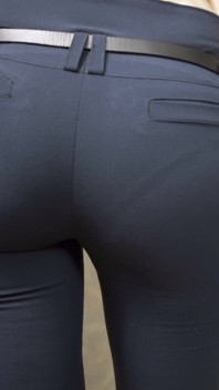 Une bombasse au cul parfait dans un pantalon de travail moulant taquine la ligne de culotte visible