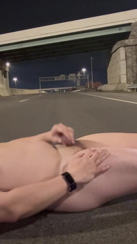 밤에 빈 도로의 한가운데로 걷는 벌거벗은 근육진 아시아인, 열심히 구부리고 엄청난 짐을 쏴