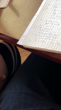 Elevă face laba din nou la ora de matematică sub masă și chiar și un pic de labă cu picioarele. la școală.