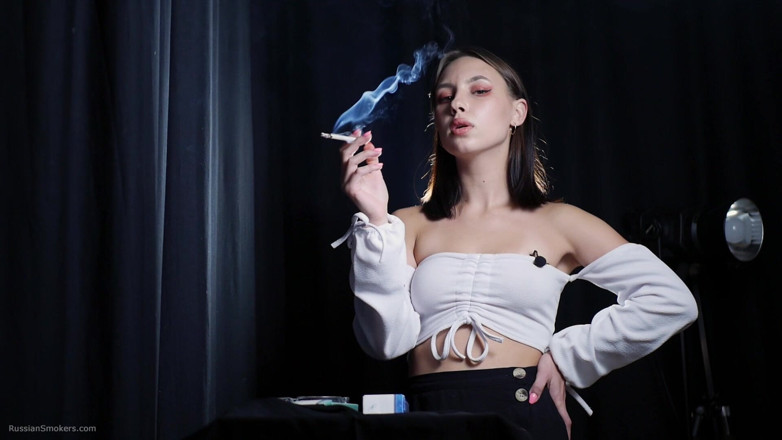 Russian Smokers: Si rambut coklat yang elegan merokok dalam adegan studio gelap