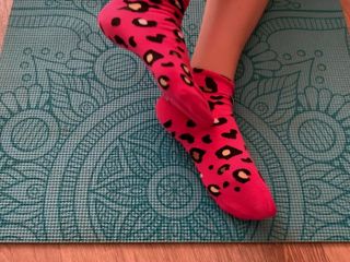 Gloria Gimson: 요가 매트에 분홍색 양말로 다리 운동을하는 운동 소녀