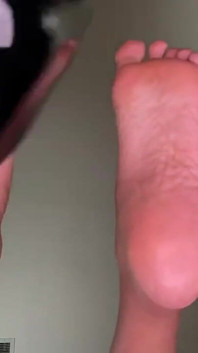Gadis kulit hitam lagi asik goyangin sepatu hak tinggi hitamnya di pinggir sofa sambil pamer kaki jenjangnya