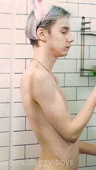 Un garçon sous la douche caresse sa crème