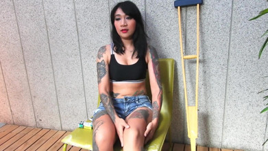 Une modèle asiatique tatouée avec une jambe courte