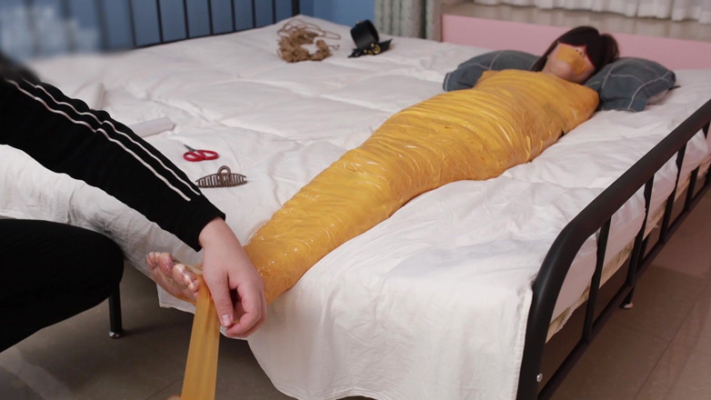 Asian bondage: Una dolce ragazza scalza usa del nastro adesivo per legare...
